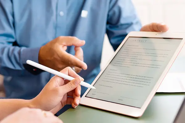 Vertreter reicht einer Frau ein Tablet zur Unterschrift