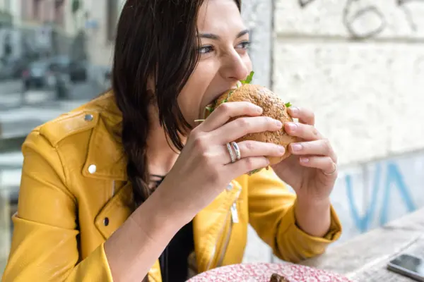 junge Frau beisst in einen Burger