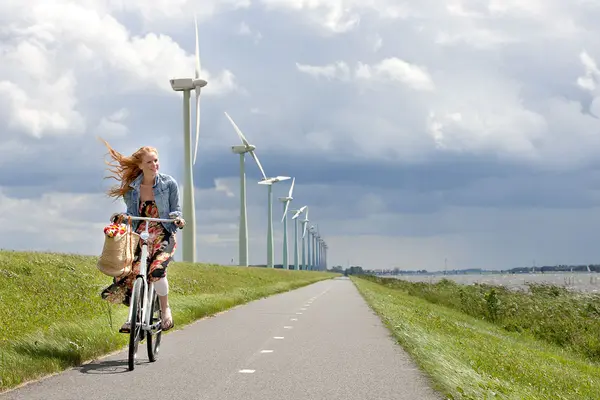 Fahrradfahrerin vor Windpark