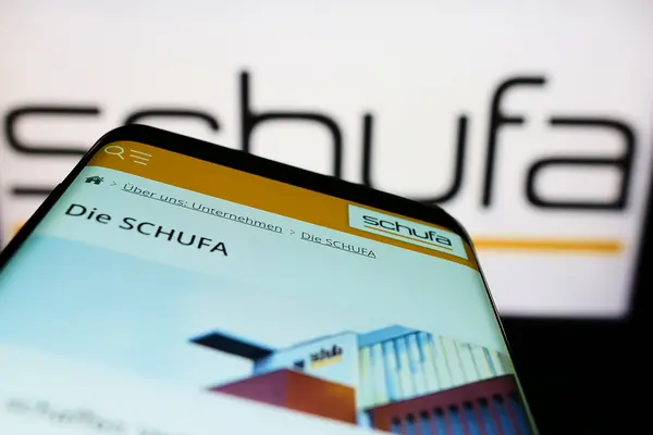 Smartphone mit Schufa-Homepage vor Schufa Logo