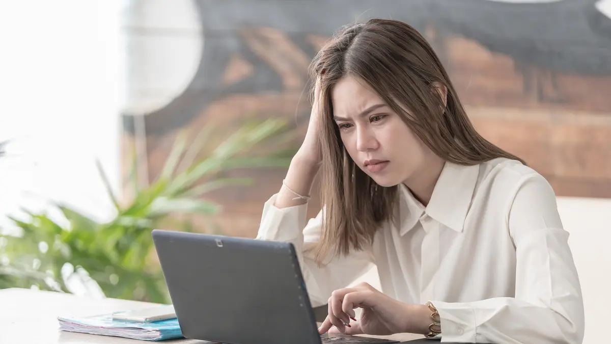 Frau sitzt verärgert vor dem Laptop