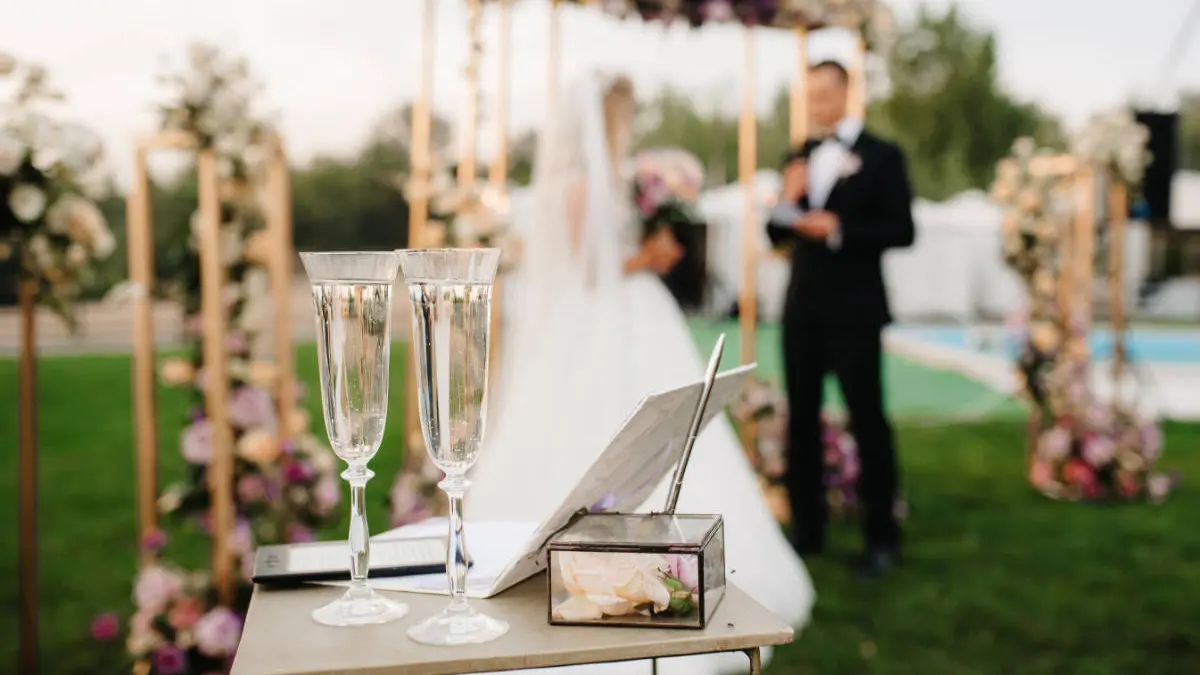 Hochzeit im Garten mit zwei Sektkelchen im Vordergrund