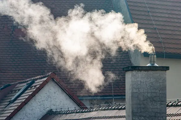 Rauch steigt aus einem Kamin auf