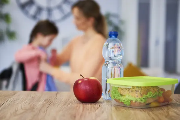 Kind geht zur Schule, dazu Wasser und Pausenbrot