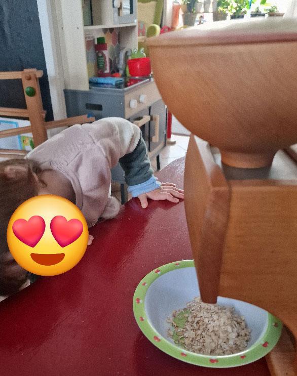 Ein Kind schaut unter die Haferflockenquetsche