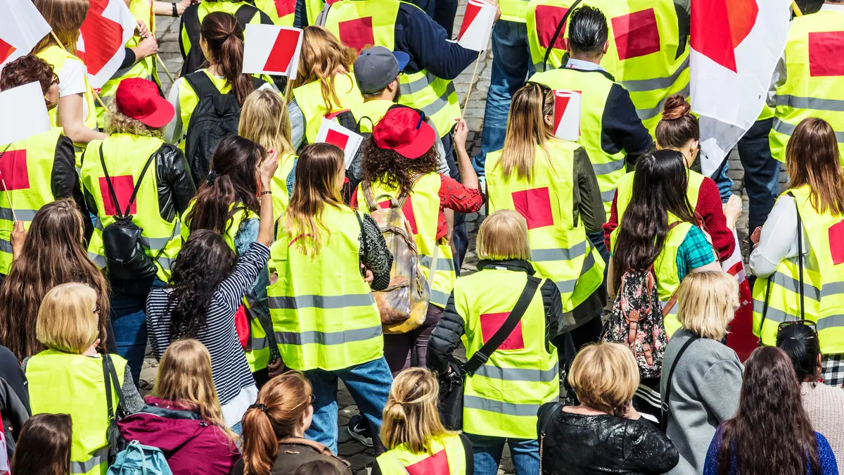 Streikende Menschen in Gewerkschaftsjacken und mit Fahnen