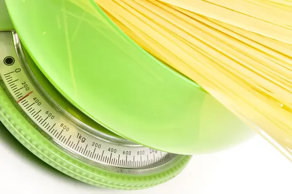 ungekochte Spaghetti auf einer grünen Küchenwaage