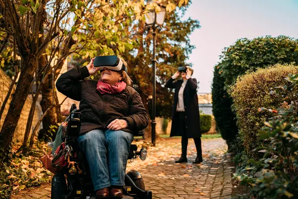 Frau im Rollstuhl schaut durch eine Virtual Reality Brille.