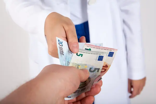 Arzt nimmt Geldscheine entgegen