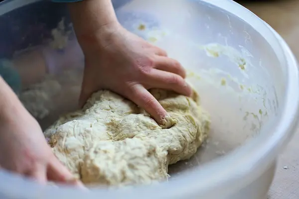 Kinderhände kneten Teig in einer Schüssel