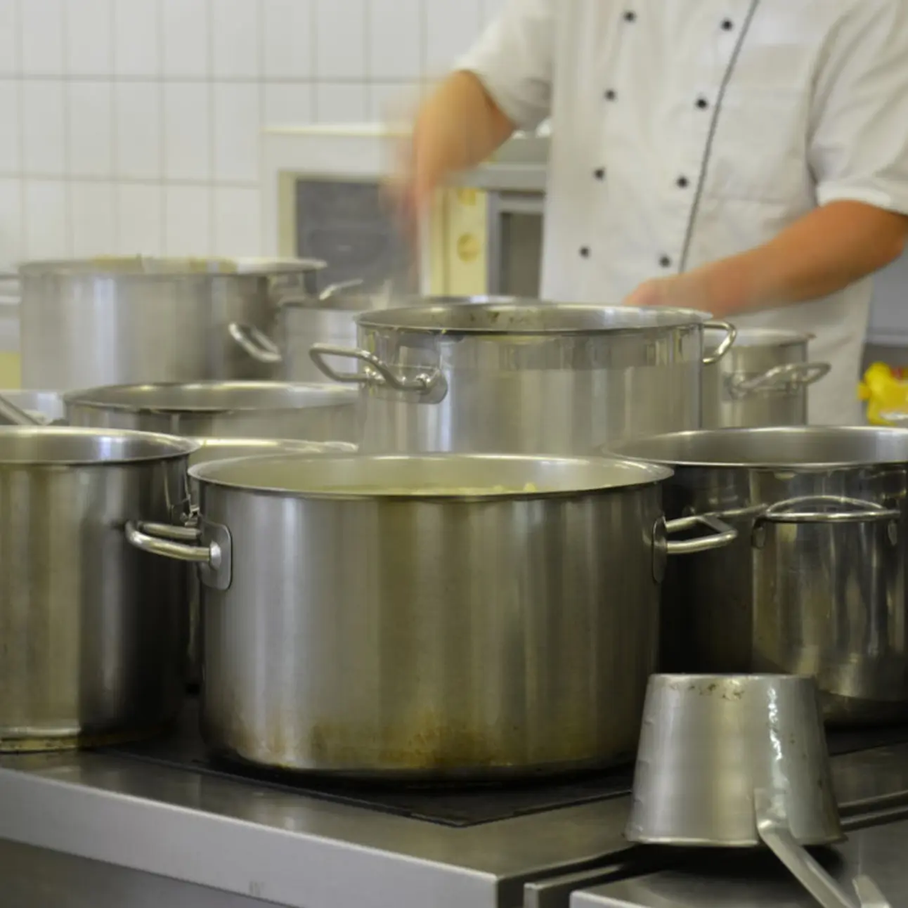 Koch rührt in Kochtöpfen 