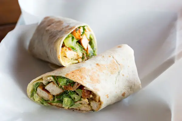 Zwei Hälften eines Wraps liegen auf einem weißen Teller