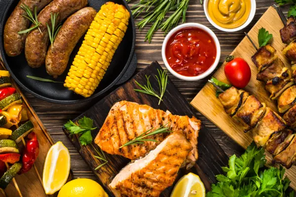 Ein gedeckter Tisch mit verschiedenen veganen, vegetarischen und fleischhaltigen Grillprodukten