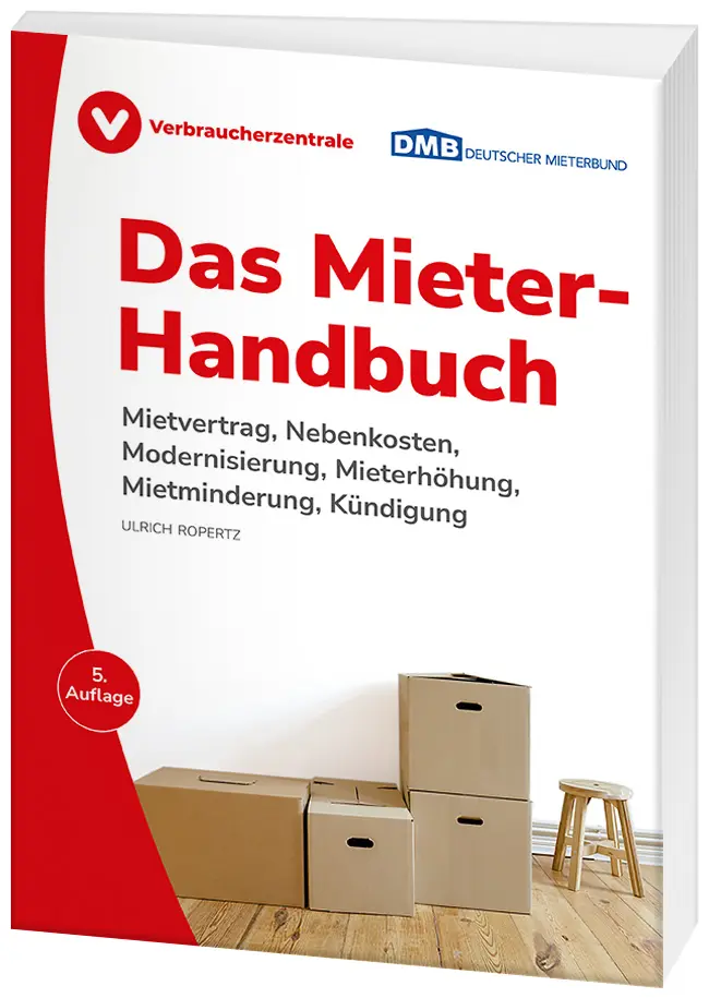 Ein Stapel Umzugkartons und ein Holzhocker stehen in einem renovierten Zimmer