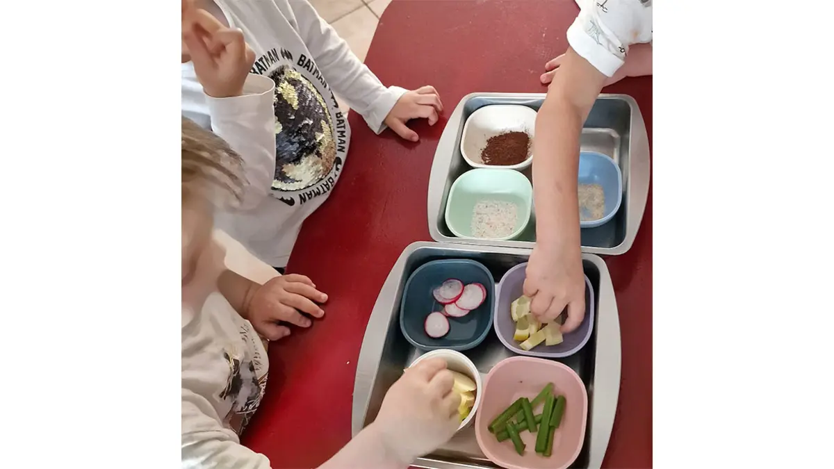 Kinder erkunden verschieden Lebensmittel, die in Schälchen auf einem tisch stehen