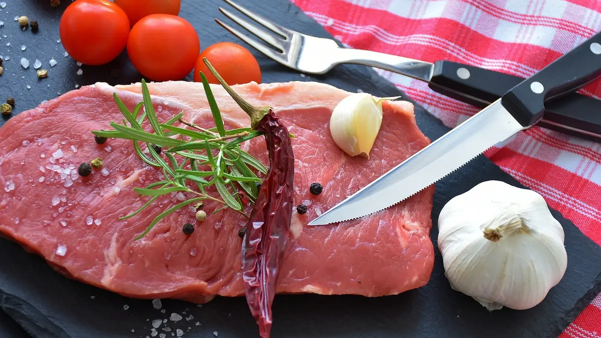 Rohes Steak mit Gewürzen, Knoblauch und Tomaten dekoriert