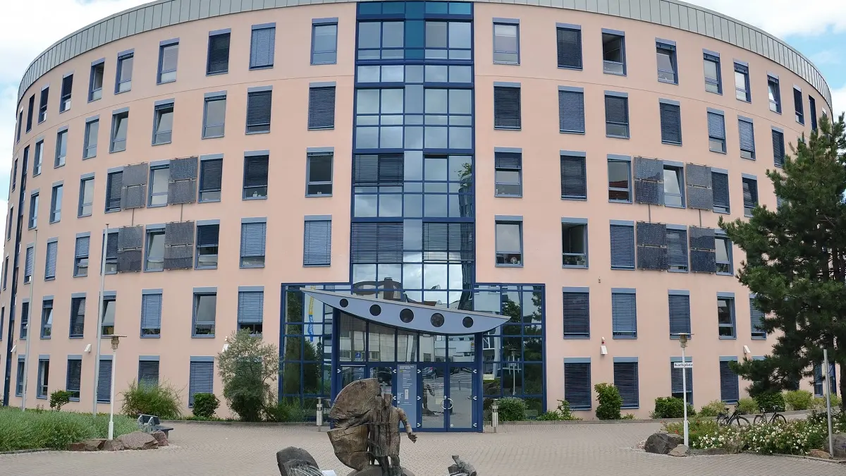 Ein Bürogebäude mit einem weiten Platz davor.
