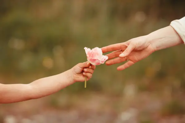Kinder und Erwachsenenhände zu sehen, Kind gibt Erwachsene Blume