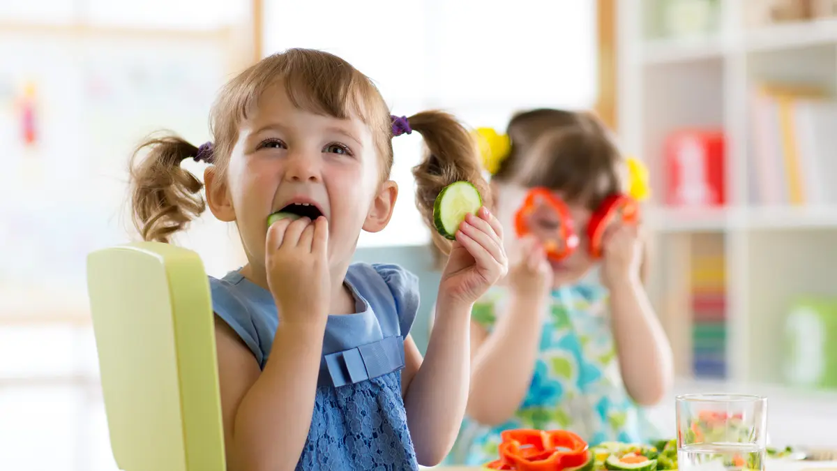 Kita-Kinder essen Gurken und Paprikascheiben