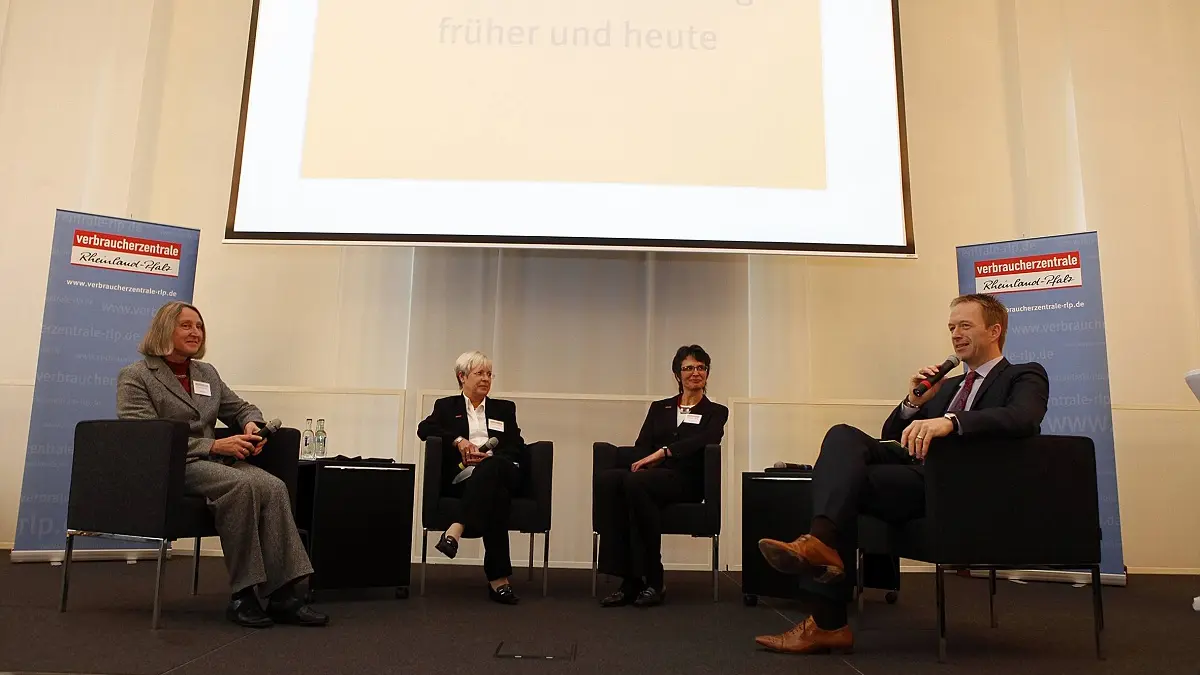 Vier Menschen diskutieren auf einer Bühne über ein Thema.