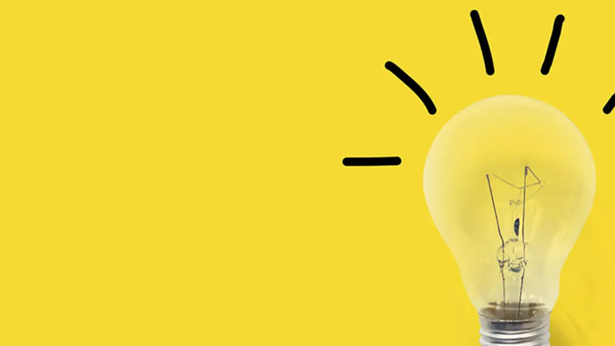 Strahlende Glühlampe vor gelbem Hintergrund - Projekt "Hessen bekämpft Energiearmut"