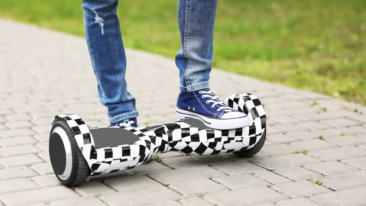 Füße einer Jugendlichen auf Hoverboard.