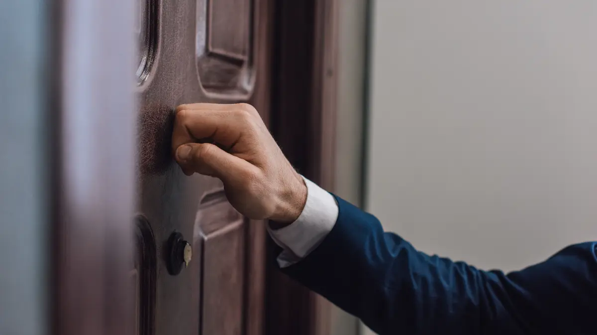 Vertreter klopft an eine Wohnungtür