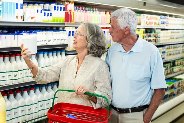 Senioren kaufen Milch im Supermarkt