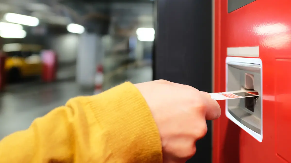 Ein Fahrgast zieht ein Ticket über einen Fahrkartenautomaten.