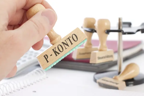 Hand hält einen Stempel mit der Aufschrift "P-Konto"
