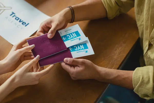 Reisepässe mit Flugtickets werden ausgehändigt.