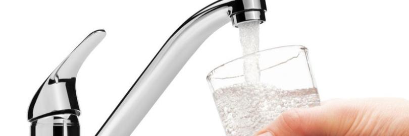 Wasserhahn mit einen Glas Wasser