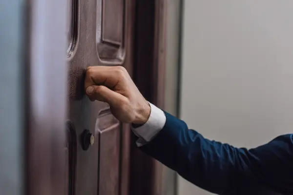 Vertreter klopft an eine Wohnungtür