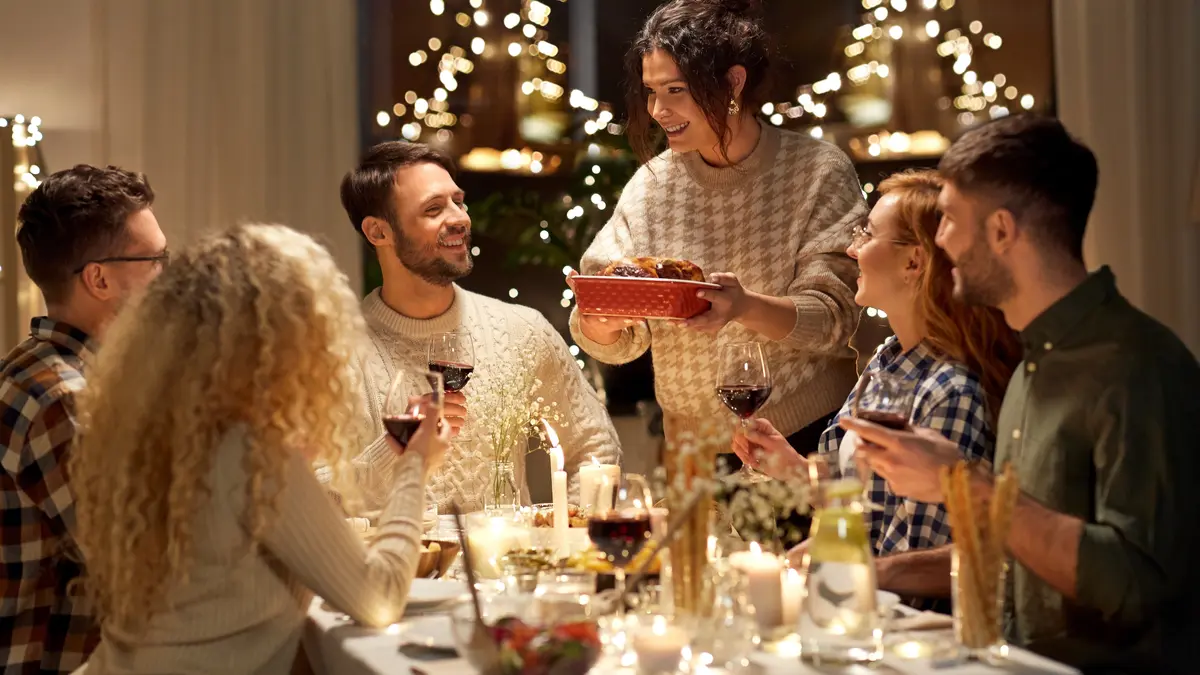 Freunde sitzen gemeinsam am Tisch und genießen ihr Weihnachtsessen