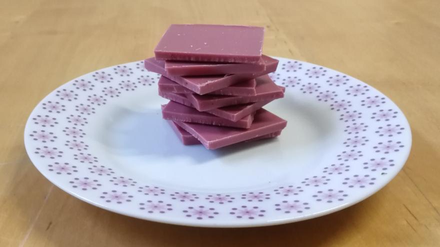 Gestapelte Stückchen Ruby-Schokolade auf einem Teller.
