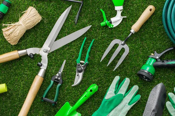 verschieden Gartenwerkzeuge liegen auf dem Rasen