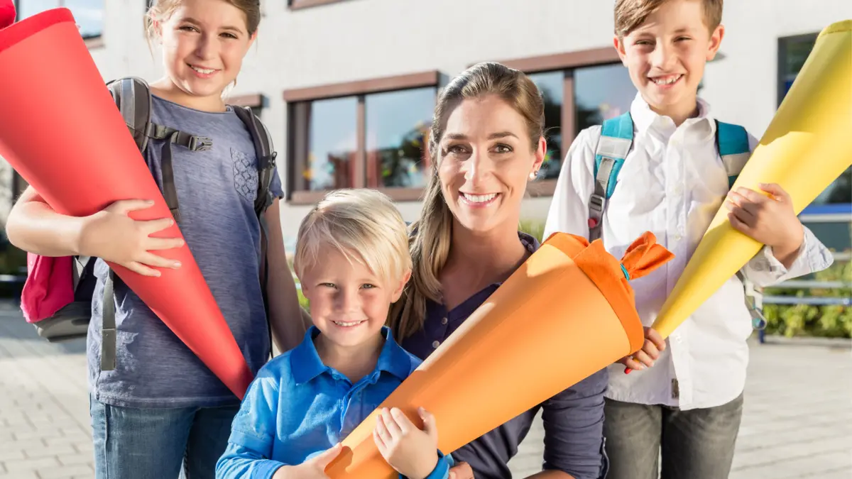 Eine Frau mit drei Schulkindern und ihren Schultüten