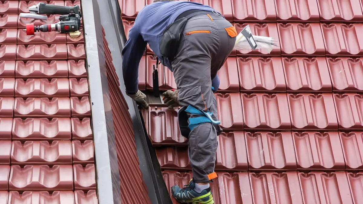 Ein Handwerker repariert ein Dach.