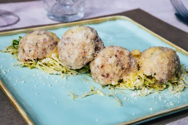 Knödel liegen auf Salat auf einem Teller