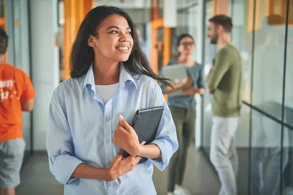 Junge Studierende geht einen Flur entlang