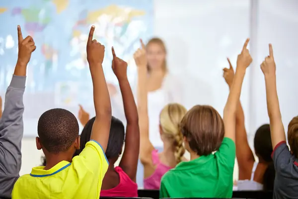 Kinder melden sich in der Schulklasse