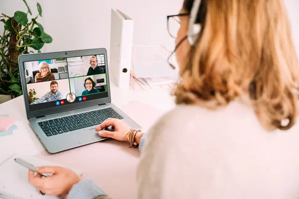 Frau vor Laptop spricht in einer Videokonferenz.