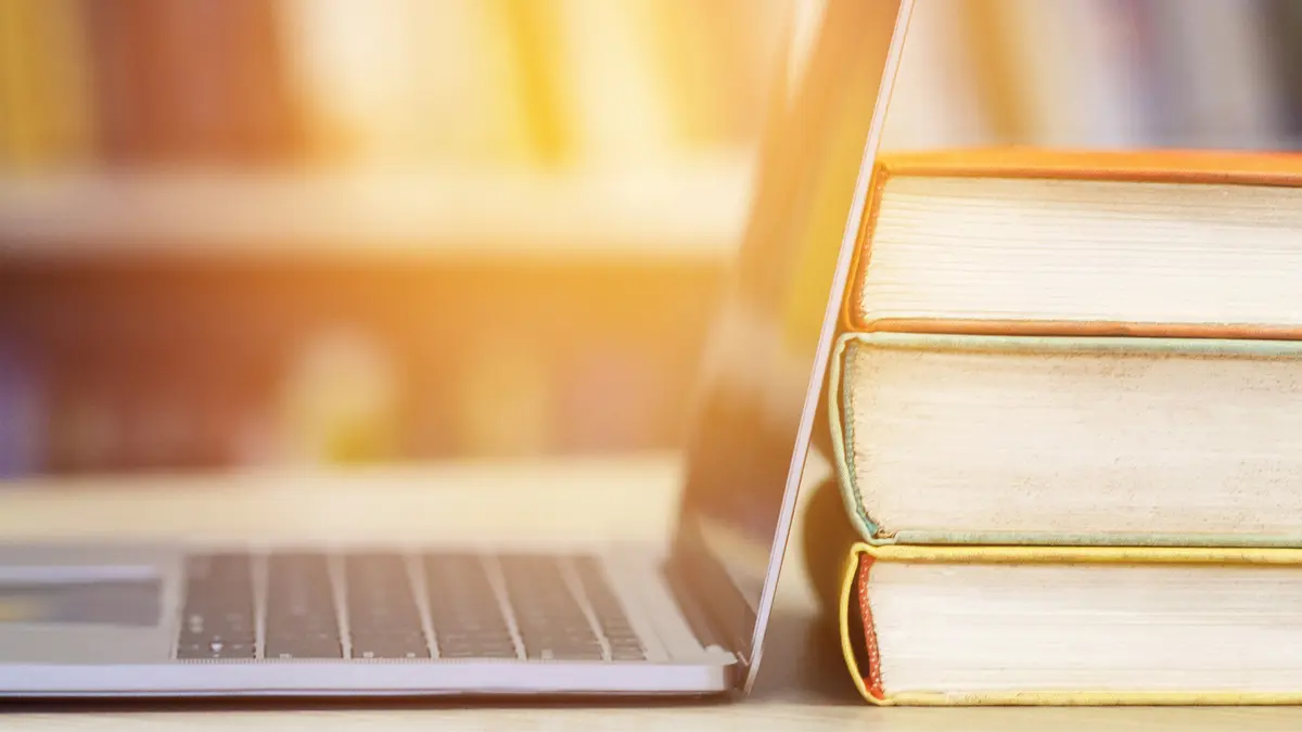 Bücher und Computer vor hellem Licht