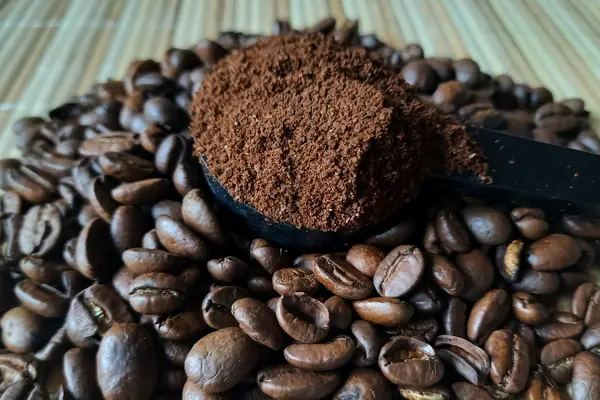 Kaffeebohnen und Messlöffel Kaffeepulver