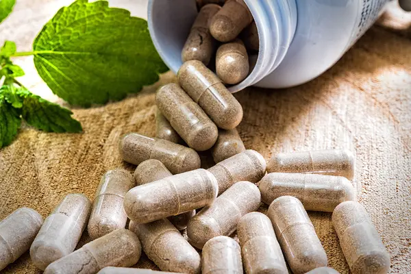 Geöffnete Dose mit Nahrungsergänzungsmitteln in Pillenform