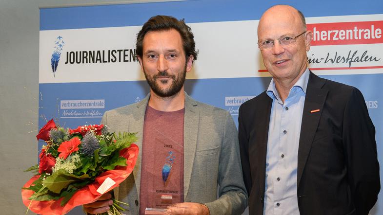 Journalist Simon Haas und Verbraucherzentrale-NRW-Vorstand Wolfgang Schuldzinski lächeln in die Kamera