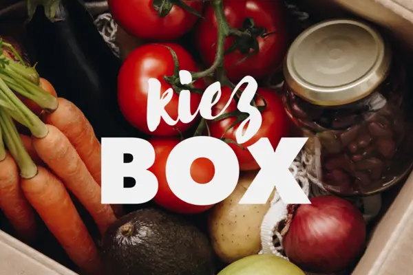 Eine Kiste mit Lebensmitteln, darüber der Schriftzug "Kiez-Box"
