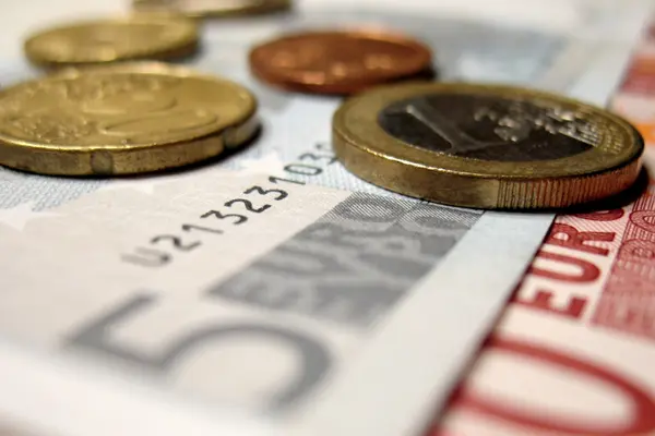 Kleine Euro-Scheine und Münzen liegen aufeinander
