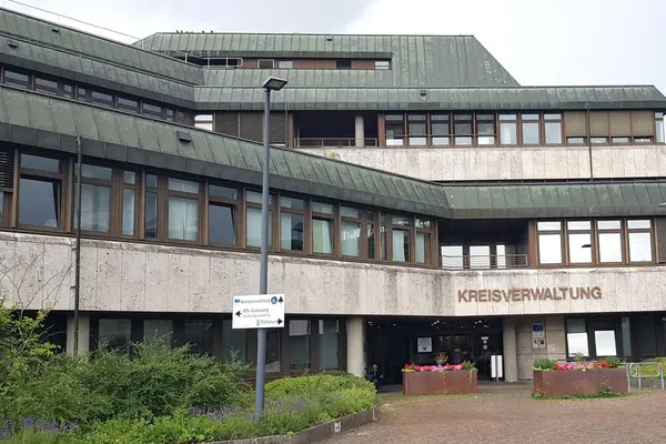 Verwaltungsgebäude aus Beton vor hellgrauem Himmel