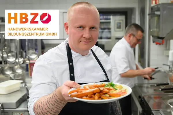 Ein Koch präsentiert einen Teller mit Essen